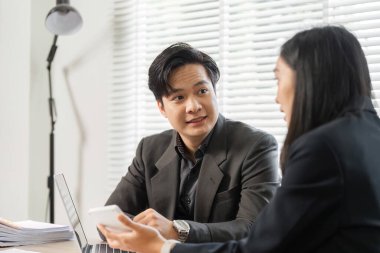 İş ortakları finansal stratejiler, takım çalışması ve modern ofis ortamında etkili iletişim konusunda işbirliği yaparlar..