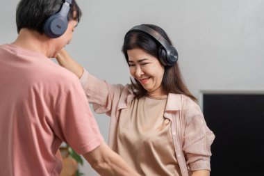 Olgun bir çift evde kulaklık takmış, neşeli bir şekilde dans ediyor müziğe dalmış ve aşklarını coşkulu bir anda kutluyor..