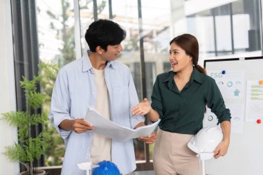 İki mühendis sürdürülebilir proje planları, takım çalışması ve çevre sorumluluğu üzerinde işbirliği yapmaktadır.