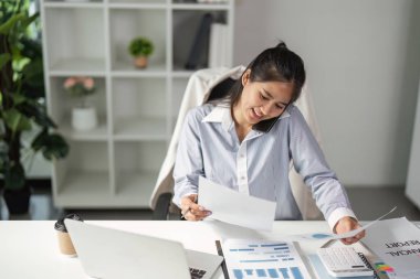 Bir finans uzmanı, önemli finansal belgeleri gözden geçirir, verimliliği ve odaklanmayı ön plana çıkarır..