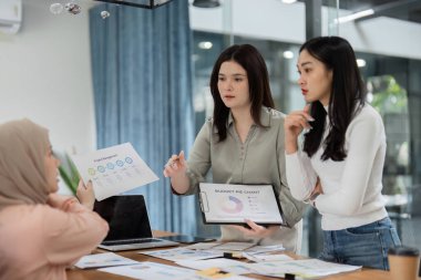 Çeşitli kadınlar bir ofis toplantısında işbirliği yapıyor, bütçe çizelgelerini gözden geçiriyor ve mali planlarını tartışıyorlar..