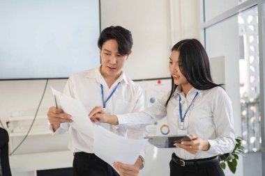 Bir çift profesyonel vergi stratejileri, belgelerin gözden geçirilmesi ve çağdaş bir ofiste tartışmaya girilmesi konularında işbirliği yapıyor..