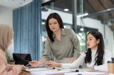 Ofis çalışanlarından oluşan bir ekip, mali stratejiler, çizelgeler ve dökümanların analizi hakkında bir tartışmaya girişiyor..