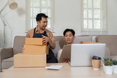 İki çevrimiçi satıcı evde takım çalışması yapıyor, paketleri hazırlıyor ve iş birliği yapıyorlar..