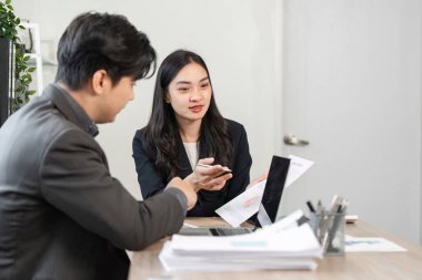 İki iş adamı, işbirliği ve analizlerin vurgulandığı mali raporlar ve stratejiler hakkında bir tartışmaya girişti.