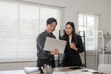 İki profesyonel proje ilerlemesi, takım çalışması ve parlak bir ofis ortamında işbirliği konularını görüştü.