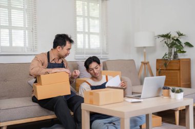 Çeşitli bir ikili, evdeki nakliye ve gelecek planlarını tartışırken çevrimiçi mağazalarının envanterini düzenler..