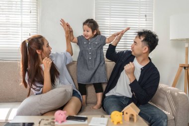 Neşeli bir aile, kızlarıyla birlikte para yönetimi ve tasarruflar hakkında eğlenceli bir öğrenim seansına katılıyor..