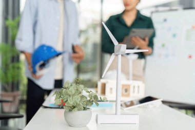 İki meslektaşı, parlak bir çalışma alanında ESG ilkelerini vurgulayarak sürdürülebilir enerji projeleri üzerinde işbirliği yapmaktadır.