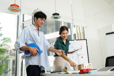 Mühendisler, modern bir çalışma alanında modelleri ve yenilenebilir enerjiyi tartışan çevre dostu tasarım projelerinde işbirliği yapıyorlar..