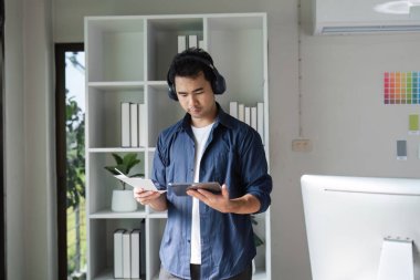 Grafik tasarımcısı çağdaş ofis ortamında renk grafiklerini analiz etmek için bir tablet kullanır, yaratıcılığı ve teknolojiyi gösterir.