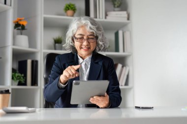 Üst düzey bir işkadını tableti ustalıkla kullanıyor ve çağdaş ofis ortamından dijital iletişim konusunda uzmanlığını gösteriyor..