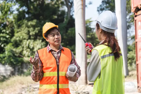 Bir lojistik mühendisi, inşaat sahasında telsiz kullanarak, etkili iletişim ve problem çözmeyi teşvik ederek, bir meslektaşına proje meydan okumalarını dile getiriyor..