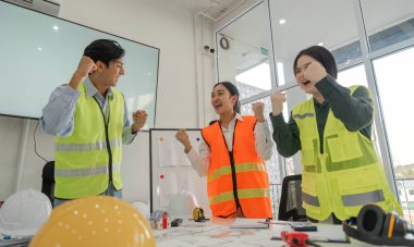 Proje dönüm noktalarını başarılı bir şekilde tartıştıktan sonra sevinç ve coşku ifade eden canlı bir inşaat ekibi, takım çalışması ve ortak çalışma alanında motivasyon sergiledi..