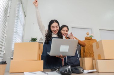 İki farklı perakende işçisi bir başarıyı sevinçle kutlarken, bir tanesi perakende piyasasında dizüstü bilgisayar kullanırken heyecanla yumruğunu kaldırıyor..