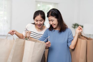 Zevkli bir kız ve anne, yeni elde ettikleri ürünleri hevesle inceleyip neşe ve bağlarla dolu doyurucu bir an yaratıyorlar..