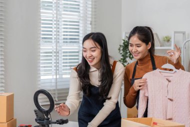 İki genç kadın, şık ev ofislerinde internet üzerinden satış yaparken arkadaşça bir atmosfer sergiliyorlar..