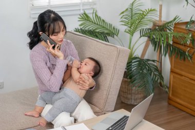 Becerikli bir anne, bebeğini beslerken telefonda konuşurken sorumluluklarını yerine getirir. Evinde sevgi dolu bir atmosfer oluşturur..