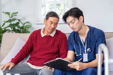 Düşünceli bir hemşire, yaşlı bir adamın dikkatle dinlediği ve evde bakım ortamında etkili bir iletişimi teşvik ettiği temel sağlık bilgilerini kaydeder..