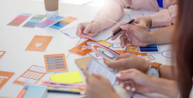 Tasarımcılardan oluşan bir ekip, tasarım konseptleri ve renk seçimleri, yaratıcılığın ve proje geliştirmenin geliştirilmesi konularında işbirliği yapar..