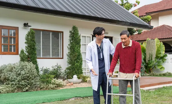 Bir sağlık uzmanı, dışarıda yürüyen bir adam kullanarak, güzel bir bahçedeki hareketlilik ve bağlantıyı desteklerken, yaşlı bir adamla sıcak bir konuşma yapar..