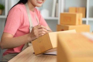 Neşeli bir işletme sahibi, küçük bir işletmeyi işletmenin zevkini yansıtan ürünleri paketlerken işinden zevk alıyor..