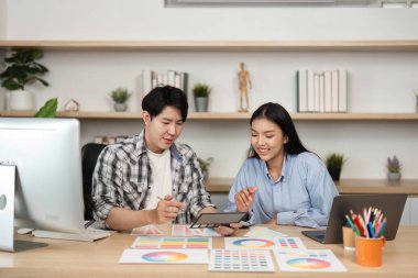 İki tasarımcı UI ve UX elementleri hakkında yaratıcı bir tartışmaya giriştiler, çağdaş bir masada fikir ve renk örnekleri paylaştılar.