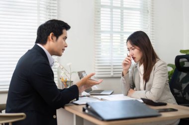 Bir mali danışman, modern ofis ortamında yatırım seçenekleri ve stratejileri tartışan bir müşteriyle temas kurar..