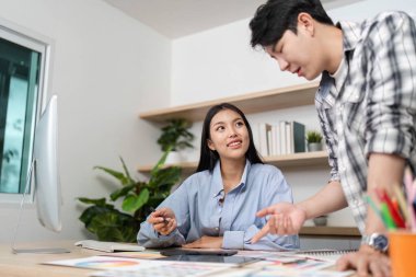 UX ve UI tasarımcıları arasında şık bir ofis ortamında fikir ve kavramları paylaşan canlı bir etkileşim..