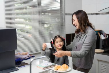 Bir anne, kızına mutfakta öğrenme aktivitelerinde yardımcı olur. Eğlenceli ve besleyici bir ortam yaratır..