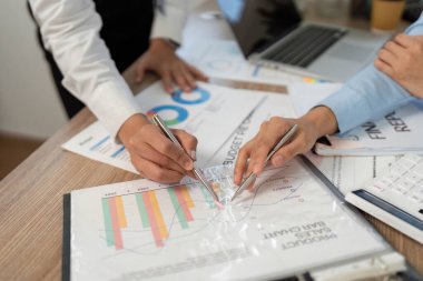 İş adamlarının elleri bütçe grafiklerini ve grafiklerini analiz eder, finansal planlamayı ve şirket ortamında takım çalışmasını vurgular.