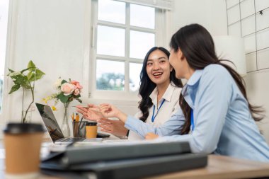 Meslektaşlar proje planları, parlak bir ofis ortamında takım çalışması ve işbirliği hakkında verimli bir tartışmaya giriştiler..