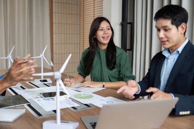 Çeşitli bir ekip, sürdürülebilirliğe olan bağlılığını gösteren ESG strateji toplantısında yenilenebilir enerji çözümlerini tartışıyor.