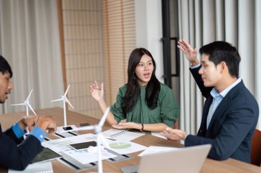 Bir ekip, toplantı sırasında ESG girişimleri ve sürdürülebilir uygulamalar hakkında etkin bir şekilde sohbet eder.