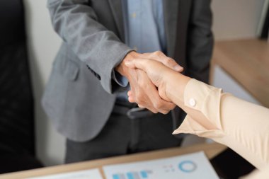İş ortakları arasındaki el sıkışma, profesyonel bir çevrede anlaşma ve işbirliğini sembolize ediyor.
