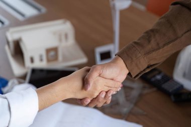 İki mimarın el sıkışması, sürdürülebilir tasarım ve ESG ilkelerini sembolize ediyor..
