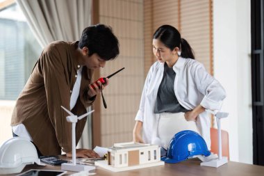 İki mimar, çalışma alanlarında gelişmiş araç ve modelleri kullanırken çevre dostu inşaatlar üzerinde strateji kuruyorlar..