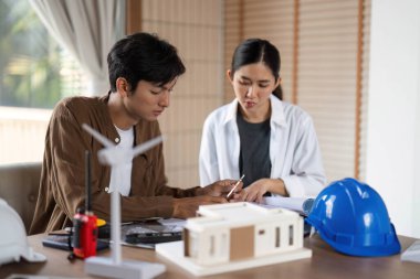 Bir erkek ve kadın mimar, çevre dostu inşaat yöntemleri ve tasarımları üzerine odaklanmış bir tartışmaya girişiyor..