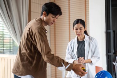 Sürdürülebilir proje planları ve modellerini inceleyen iki mimar, tasarımlarında çevre dostu uygulamaları vurguluyor.