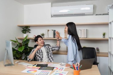 Bir tasarım ekibi, üretken bir tasarım oturumundan sonra, takım çalışmasının altını çizerek modern bir çalışma alanında bir kutlama anının tadını çıkarıyor..