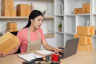 Adanmış bir girişimci, küçük işletmesindeki paket yönetimi ve dijital yönetimi dengeler..