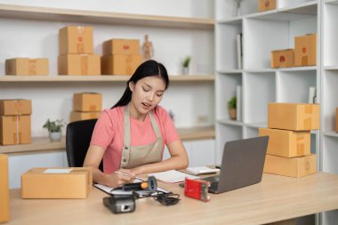 Girişimci, lojistiği yönetirken çalışma alanını düzenler ve küçük işletmesi için ayrıntıları not eder.