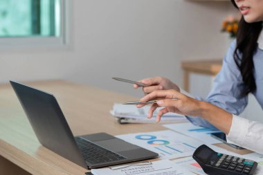 Uzaktan finansal bir tartışmada yer alan iki profesyonel, bir dizüstü bilgisayardaki verileri analiz ediyor ve görüşlerini paylaşıyor..