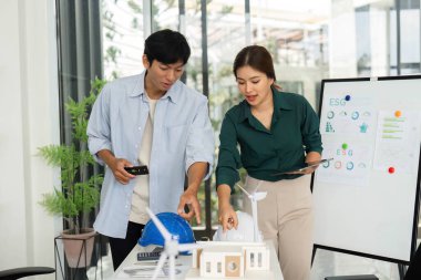 İki mimar sürdürülebilir bir binanın modelini analiz ederek, modern ofis ortamında ESG ilkelerini ve takım çalışmasını ön plana çıkarıyor..