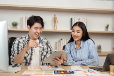 UX ve UI elementlerini değerlendiren iki tasarımcı arasındaki dinamik değişim modern bir çalışma alanında yaratıcılığı teşvik ediyor..