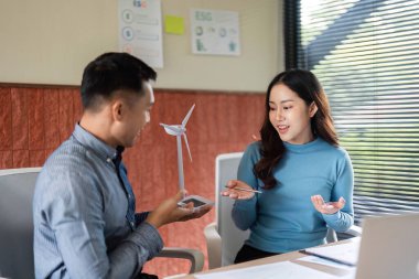 ESG girişimleri, takım çalışması ve yenilikçi düşünceler hakkında konuşan bir kadın ve erkek..