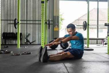 Bir adam spor salonunda esneklik ve fiziksel sağlığı arttırmak için forvet oynuyor. Zindelik ve sağIık için birebir..