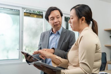 İki meslektaş tabletler hakkındaki verileri analiz ediyor, görüşleri paylaşıyor ve modern bir çalışma alanında işbirliğini teşvik ediyor.