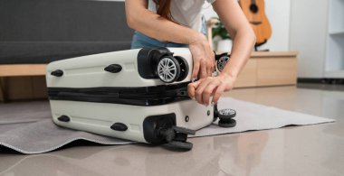 Bir kadın evdeki bavulunun tekerleklerini tamir ediyor. Yolculuk takımlarının en iyi durumda olduğundan emin oluyor..