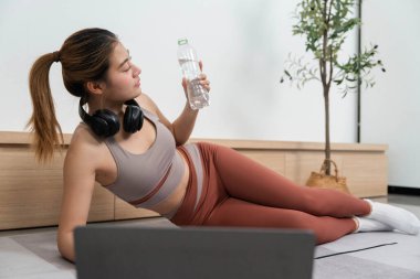 Rahatlamış bir kadın yoga seansından sonra bir anlık susuzluğun tadını çıkarıyor, rahatlığı ve huzuru kucaklıyor..